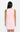 Person wearing a light pink sleeveless dress on a white background