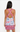 Woman wearing a sleeveless dress with a colorful pattern on a white background