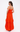 Woman wearing an orange tiered dress on a white background