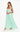 Woman wearing a light green evening gown with ruffled details on a white background