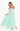 Woman wearing a light green ruffled dress on a white background