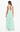 Woman wearing a light green halter neck dress with a flowing design on a white background