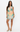 Woman wearing a sleeveless dress with palm tree design on a white background