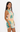 Woman wearing a sleeveless top and shorts with a palm tree and sunset design on a white background
