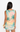 Woman wearing a sleeveless dress with palm tree and sunset design on a white background