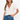 Woman wearing a white crochet top and denim shorts on a white background