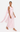 Woman wearing a light pink gown with a flowing train on a white background
