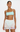 Woman wearing a light blue top and white crochet skirt on a plain background