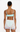 Woman wearing a light blue bikini top and white crochet skirt with floral details on a white background