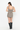 A woman shown from the back wearing a sleeveless mini romper with a brown, beige, and black gingham pattern, paired with black knee-high boots, against a plain white studio background.