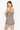 A model wearing a brown, beige, and black gingham halter romper, photographed from the back against a clean white studio background.