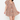 A woman modeling a short, ruffled mini dress with a dense multicolor floral print in orange, blue, and green on a beige base, paired with brown cowboy boots against a plain white studio background.