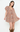 A woman modeling a short, ruffled mini dress with a dense multicolor floral print in orange, blue, and green on a beige base, paired with brown cowboy boots against a plain white studio background.