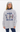Woman wearing a baggy sweatshirt in gray with the Alpine Ski Club graphic.