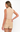 A woman shown from the back wearing a sleeveless beige mock-neck top and matching beige shorts against a plain white studio background.