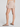 Person wearing a beige skirt and tights on a plain background