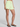 Person wearing light green shorts on a plain background