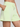 Light green shorts worn by a person on a plain background