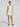Woman wearing a light green sleeveless top and shorts set on a plain background