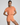 Woman wearing a peach-colored athletic outfit on a plain background