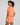 Woman wearing an orange athletic outfit on a plain background