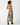 A woman modeling a sleeveless halter-neck maxi dress with a zebra print pattern, shown from the back against a plain white studio background.