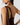 Close-up back view of a model wearing a dark brown satin halter dress with a structured gold-tone ring detail at the shoulder strap.