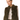 A model wearing a cropped, olive green faux fur vest over a light beige top and olive green trousers, photographed against a solid white background.