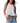 Woman wearing a white halter top and denim shorts on a white background