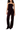 A model wearing a dark plum velvet strapless top and matching wide-leg trousers, paired with black pointed-toe heels, against a plain white background.