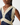 Close-up of a woman wearing a navy blue satin-like dress with wide cream lace trim and a buttoned lace neckline.