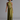 A woman modeling a sleeveless olive green halter maxi dress with a textured, patterned waist panel, photographed against a solid gray studio background.