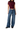 A model wearing a dark burgundy wrap-style short-sleeve crop top and wide-leg blue denim jeans, paired with black shoes, against a plain white background.