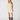 A woman modeling a cream-colored sleeveless mini dress with delicate lace detailing on the bodice and a flared skirt, paired with brown cowboy boots, against a plain light gray background.