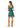 A woman shown from the back wearing a teal green sleeveless dress with a white polka dot pattern, ruffled cap sleeves, and a tie at the back of the neckline. She is also wearing tan knee-high boots against a plain white background.