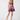 A woman modeling a short, sleeveless mini dress with thin straps and a floral print in shades of purple, pink, and blue, set against a plain light gray studio background.