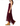 A woman modeling a sleeveless burgundy maxi dress with a sheer lace hem, paired with tan ankle boots, shown from a side profile against a white background.