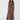 A woman modeling a long-sleeve, high-neck maxi dress with a brown, black, and beige spotted animal print, paired with nude high-heeled sandals, against a plain white background.