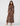 A woman modeling a long-sleeve, high-neck maxi dress with a brown, black, and beige spotted animal print, paired with nude high-heeled sandals, against a plain white background.