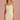 Woman wearing a light yellow dress with button details on a pink background