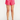 Pink shorts worn by a person on a white background