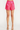 Pink shorts worn by a person on a white background