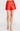 Red satin skirt worn by a person on a white background