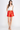 Woman wearing a white tank top and red shorts on a white background