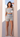 Woman wearing a patterned outfit standing in a doorway.