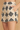 Close-up of a person wearing high-waisted crochet shorts with a diamond argyle pattern in beige and black, featuring a side pocket and scalloped hem.
