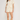 Woman wearing a cream-colored outfit with a white background