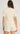 Woman wearing a cream-colored lace outfit on a white background