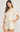 Woman wearing a cream-colored crochet outfit on a white background