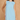 Woman wearing a light blue dress with floral details on a beige background